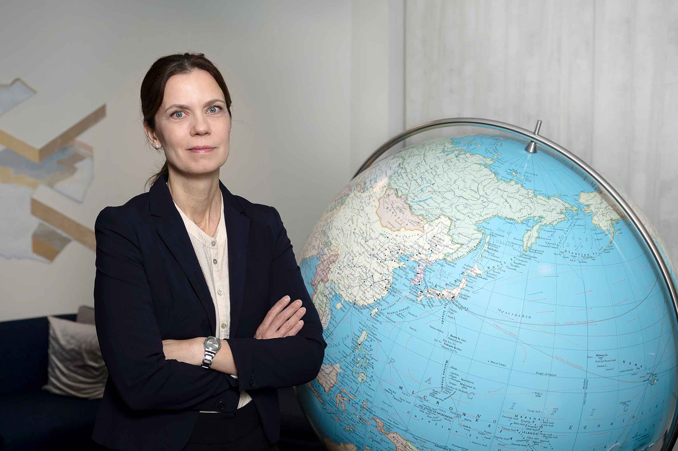 Karin Wessman står vid sidan av en stor jordglob