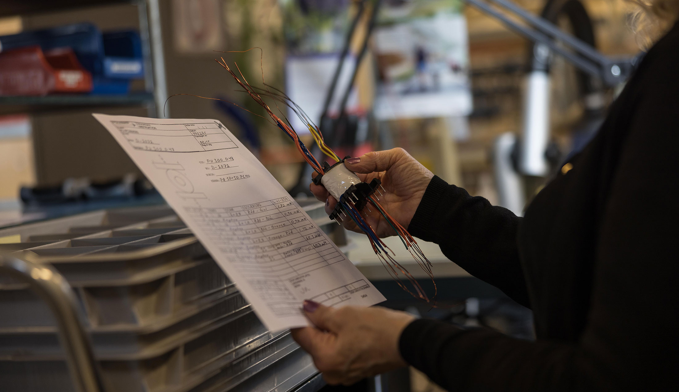 En medarbetare i Polyamps fabrik kvalitetskontrollerar en komponent.