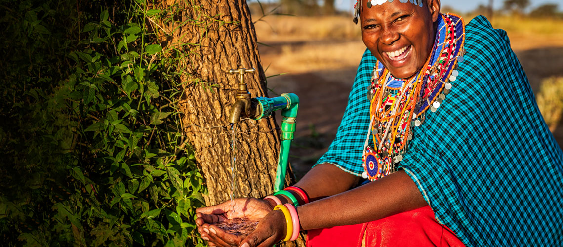 African woman holding her hands under tap with running water