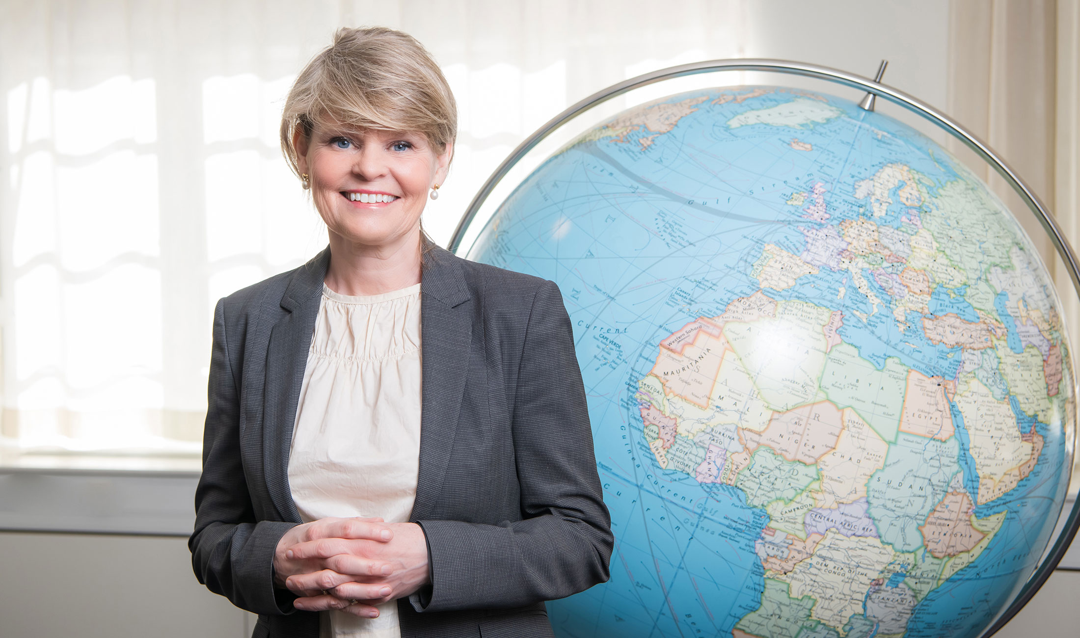 Lena Bertilsson in front of a globe.