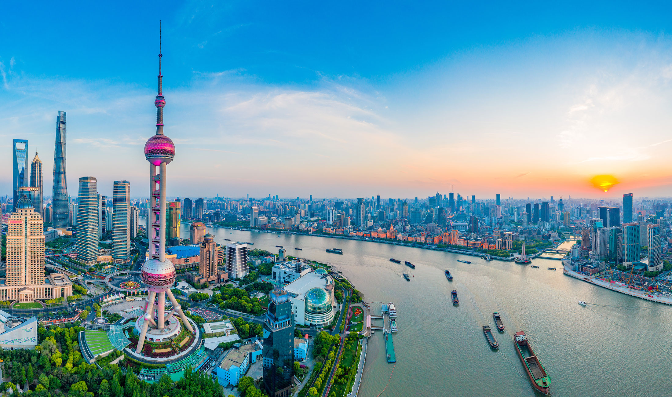 Vy över Shanghai i Kina med höghus och floden med fraktfartyg