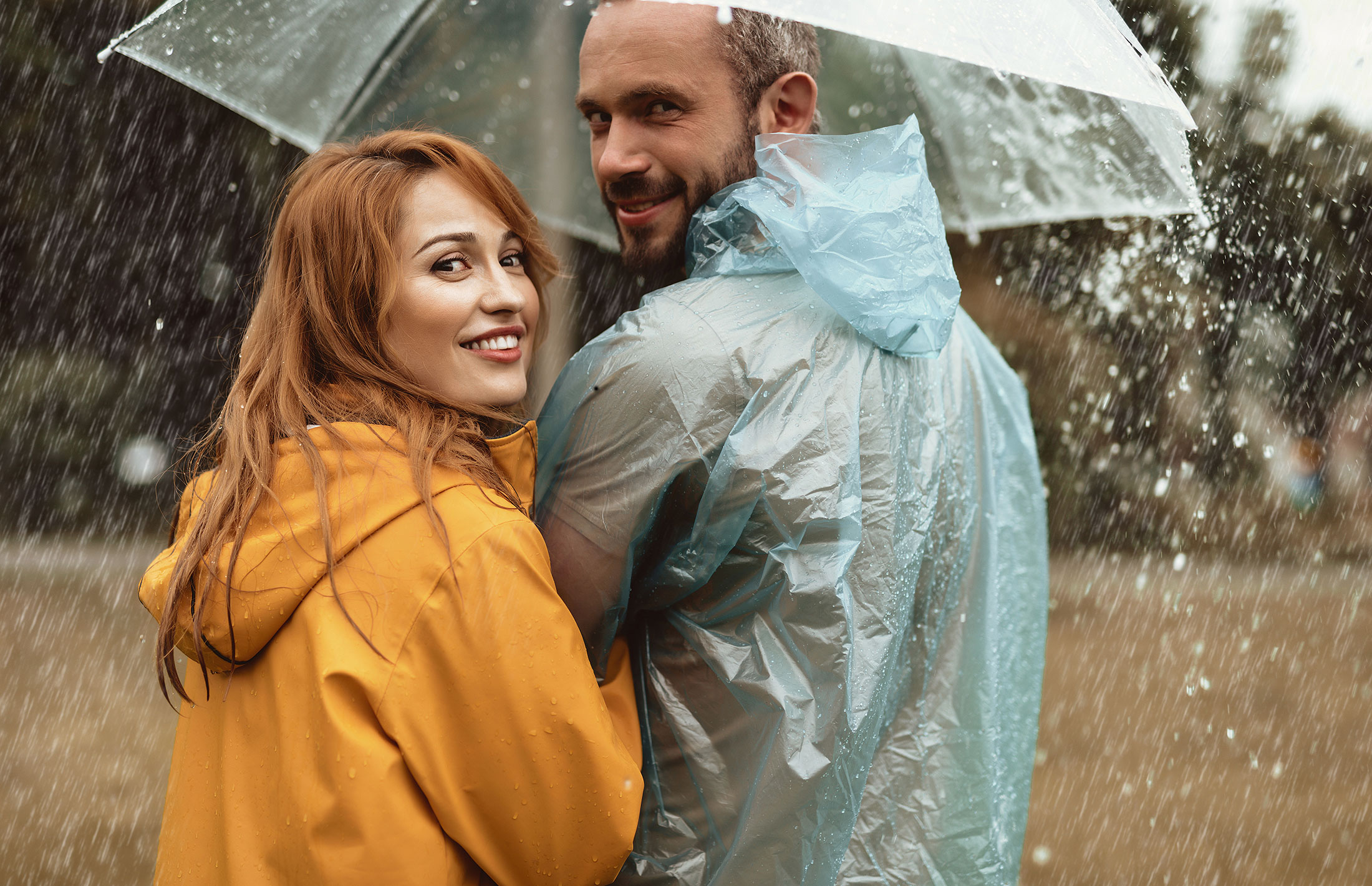 A man and a woman under an umbrella in the rain