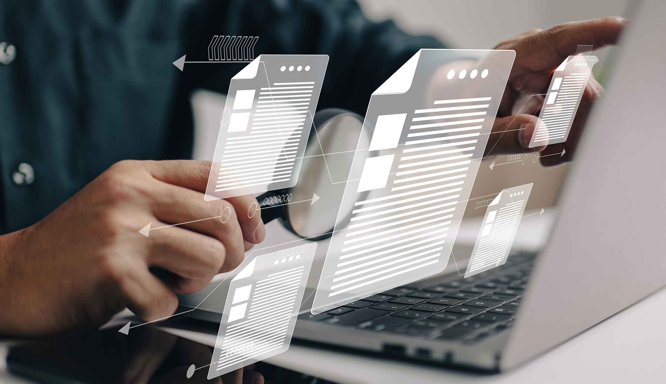A person is sitting in front of their computer with a magnifying glass. Digital documents are emerging from the screen.